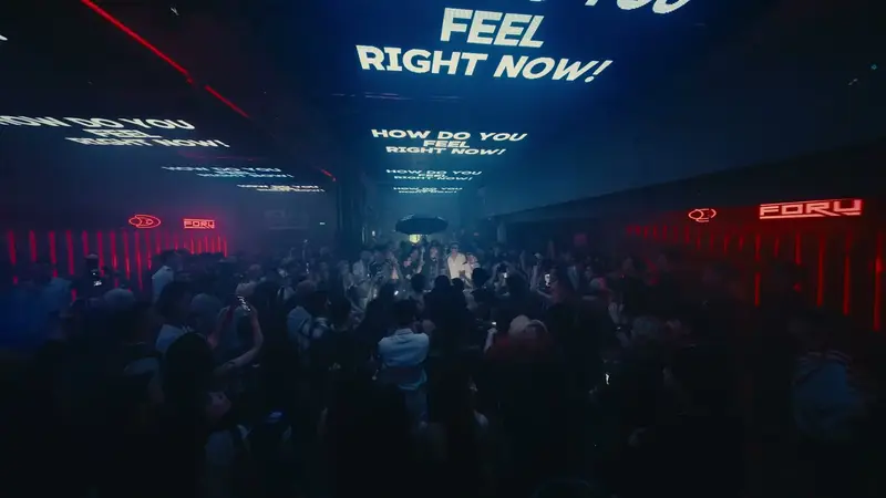 Màn LED trên trần KHU 13 chạy dòng chữ “Feel right now”, khán phòng tối bên dưới